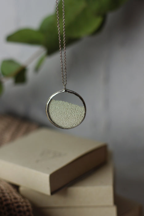 Silver ball perpetual motion necklace